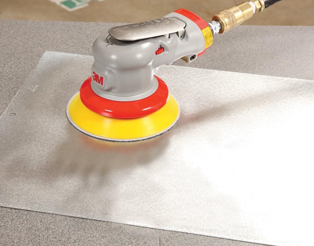 3M 20317 held in hand for scale showing compact palm sander ergonomics