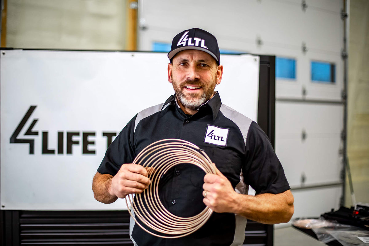 4LIFETIMELINES mechanic installing brake line in garage showing practical repair benefit
