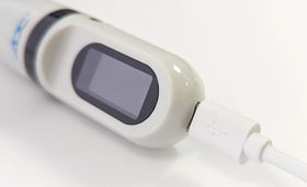 ADC Adtemp‑Mini 432 connected to micro USB cable while charging for travel readiness