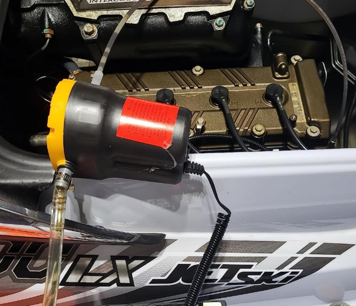 Amarine Made pump in use extracting oil from a car for fast maintenance