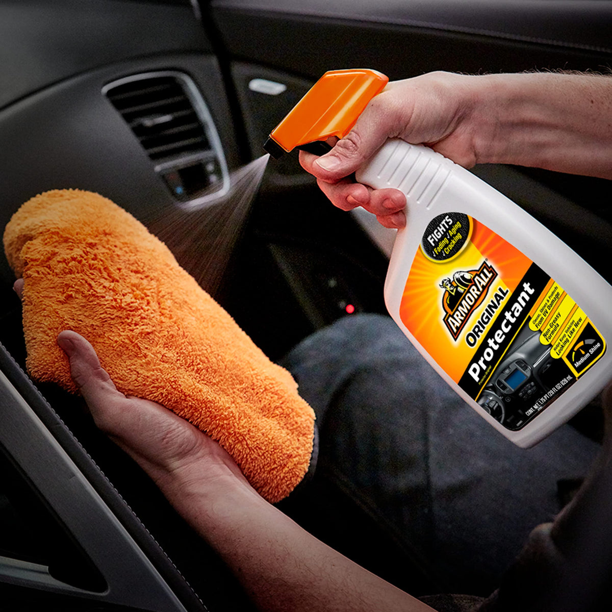 Armor All being sprayed on a dashboard demonstrating quick cleaning