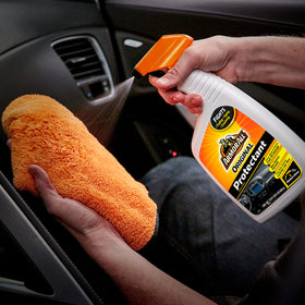 Armor All being sprayed on a dashboard demonstrating quick cleaning
