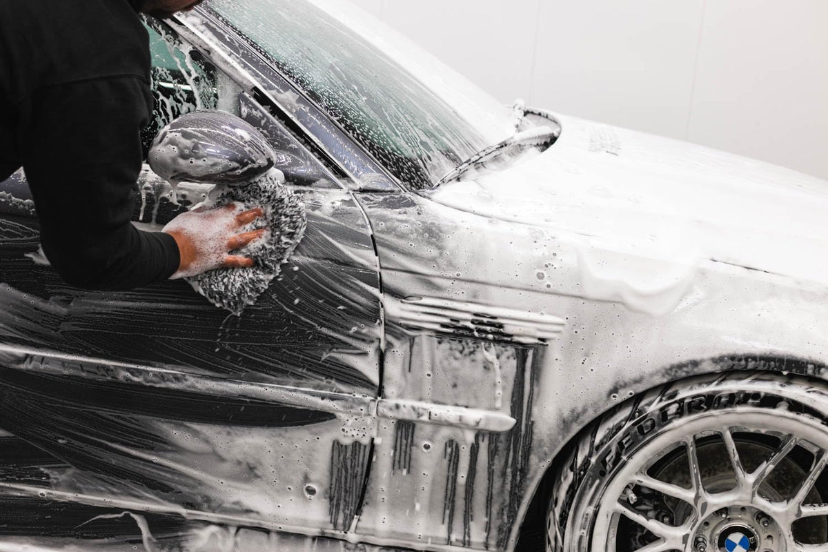 Armour Detail Supply product in use washing car in a driveway setting