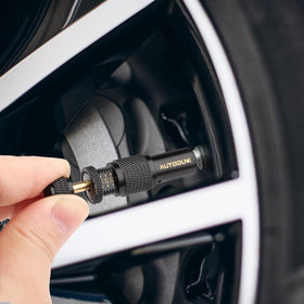 AUTODUNK valve attached to SUV tire demonstrating hands-free automatic deflation