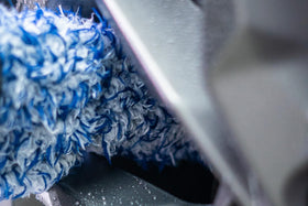 Autofiber brush in use between wheel spokes removing brake dust for faster detailed cleaning