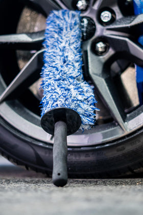 Autofiber brush held next to ruler showing 17 inch length and ergonomic reach advantage