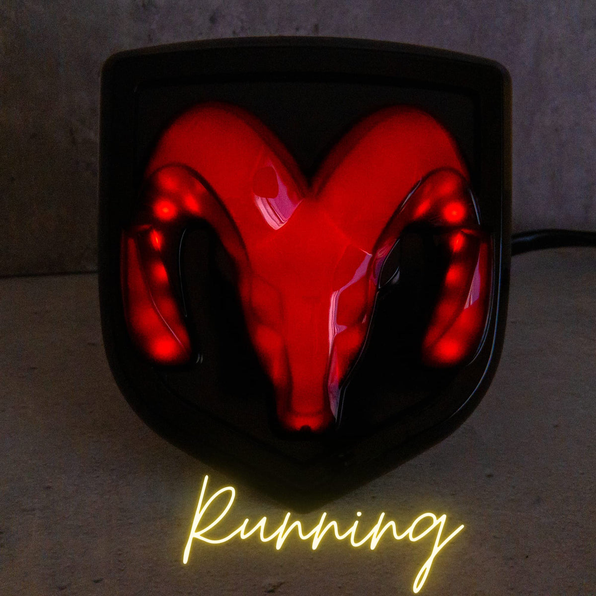 Autogem close-up of RAM logo where red LEDs shine through metalized finish