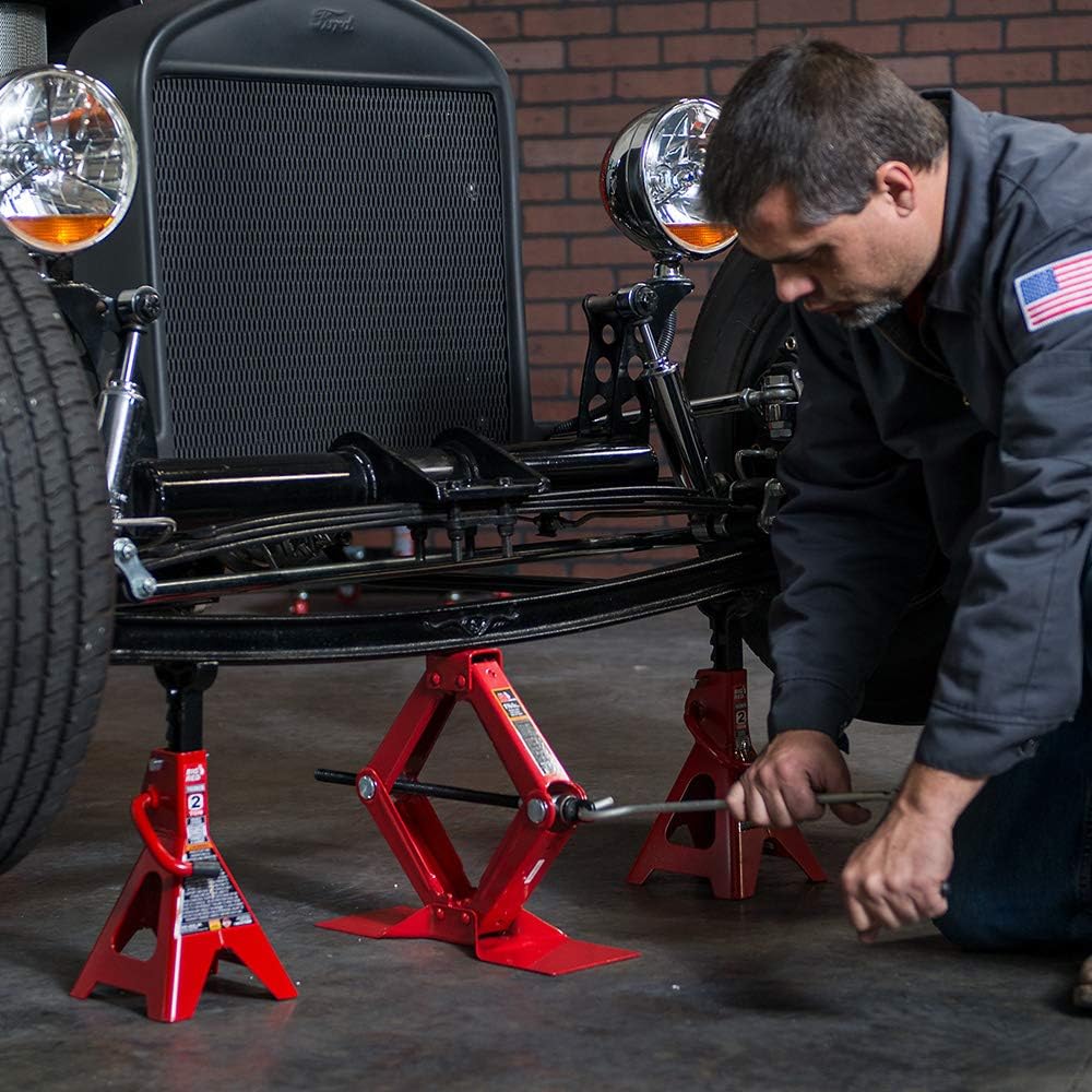 BIG RED lifting a car wheel demonstrating emergency roadside use