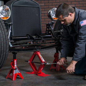BIG RED lifting a car wheel demonstrating emergency roadside use