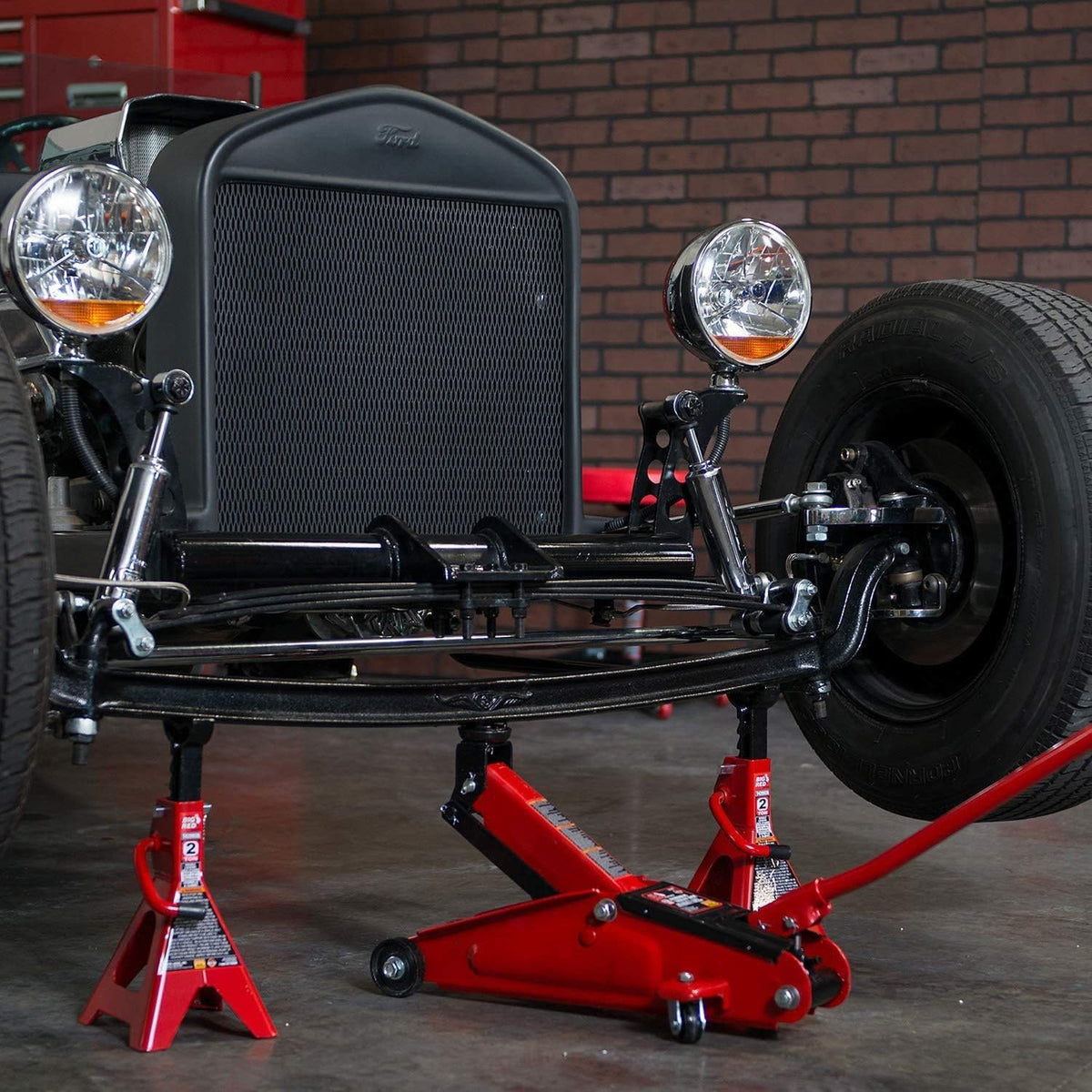 BIG RED jack next to tape measure showing low-profile lift range for fitment benefit
