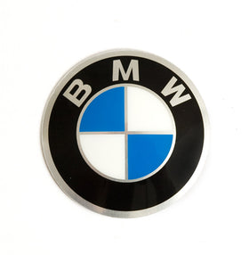 BMW plaque on vehicle surface with adhesive film applied demonstrating secure fit