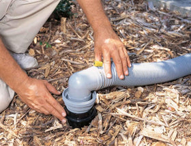 Camco Easy Slip elbow connected at a dump station demonstrating faster flow