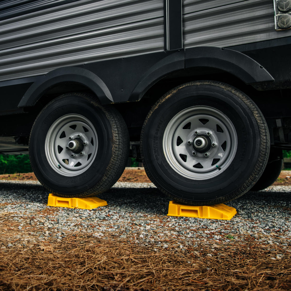 Camco FasTen ramps beside an RV at campsite illustrating reliable on-site use