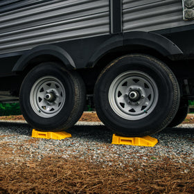 Camco FasTen ramps beside an RV at campsite illustrating reliable on-site use