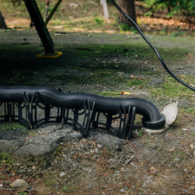 Camco hose routed from RV to dump at campsite for quick setup