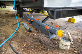 Camco in-use over curb demonstrating guided hose travel benefit