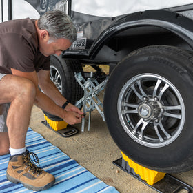 Camco beside a boot for size comparison illustrating easy handling and storage