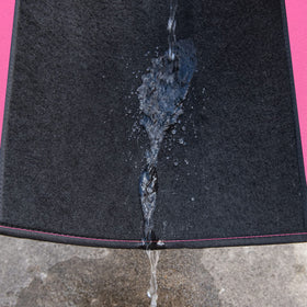 CAR PASS mat under running water showing waterproof easy-clean benefit
