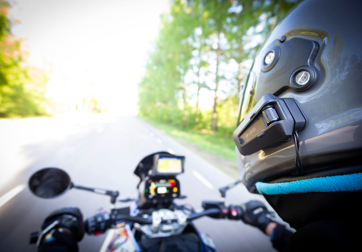 Two Cardo PACKTALK PRO units in a riding lifestyle scene enabling effortless group communication