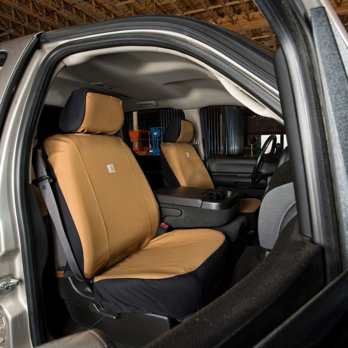 Carhartt folded seat cover next to ruler showing compact storage and vehicle fit