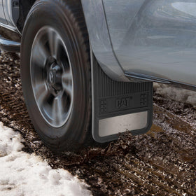 CAT mud flap mounted on truck rear protecting wheel well