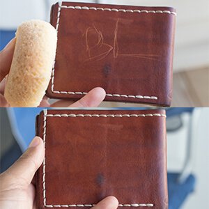 Hand using Chamberlain's Leather Milk on sofa armrest, illustrates easy in-home restoration