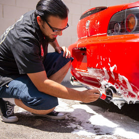 Chemical Guys brush detailing a badge and emblem to lift grime without scratching