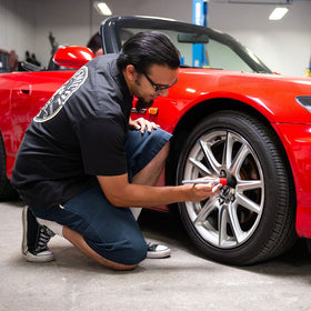 Chemical Guys brush used on a textured grille for precise dirt removal and finish care