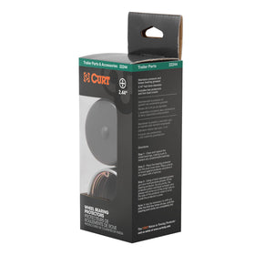 CURT dust cover beside a ruler showing size and 2.44-inch hub bore compatibility benefit