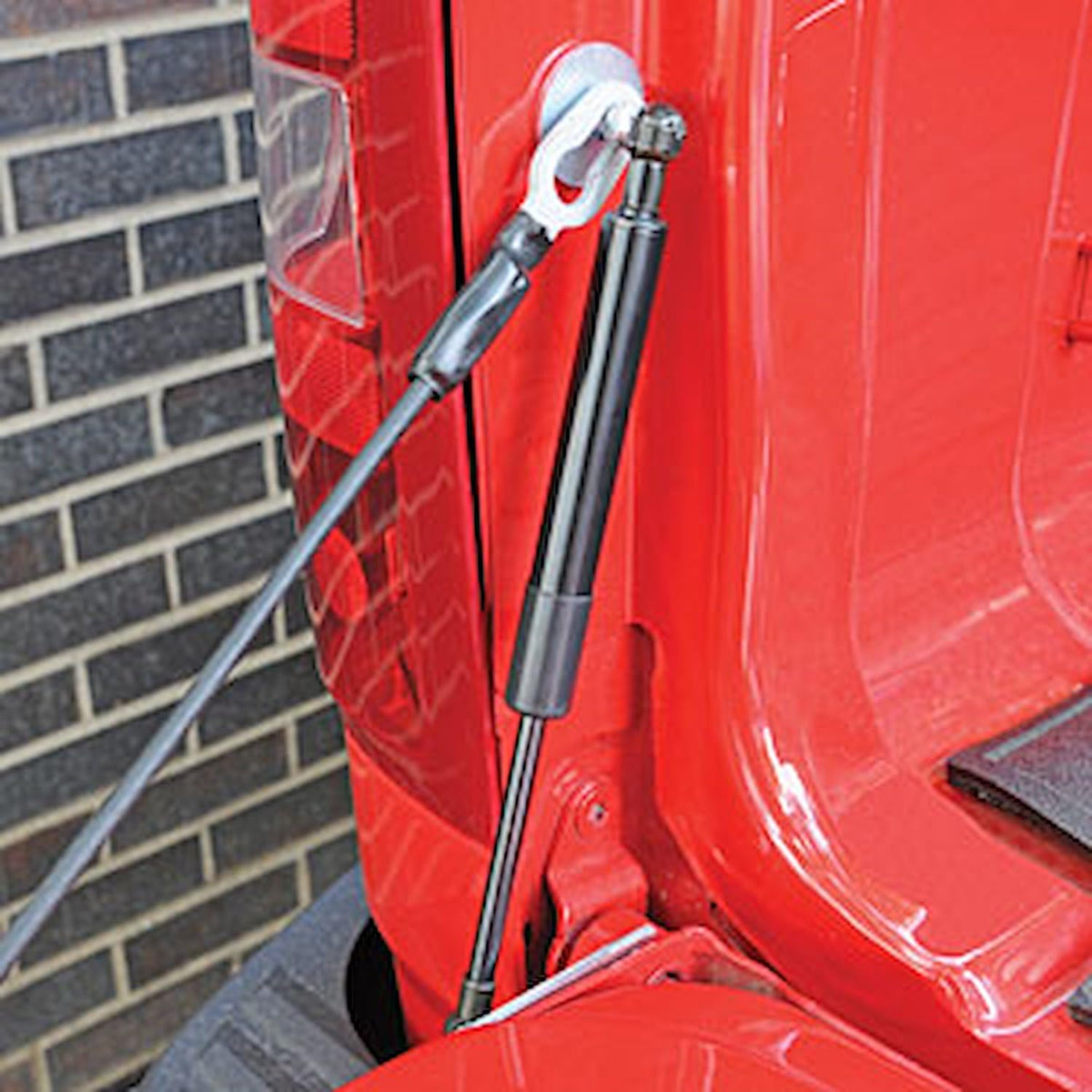 DEE ZEE tailgate assist mounted in truck demonstrating controlled lowering benefit