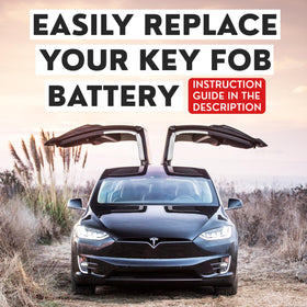 Tesla key fob on a car console with Deluxe Batteries pack nearby, convenient at-home fix