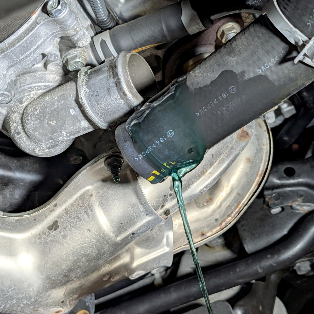 Design Engineering DEI bottle being added to car radiator showing improved cooling