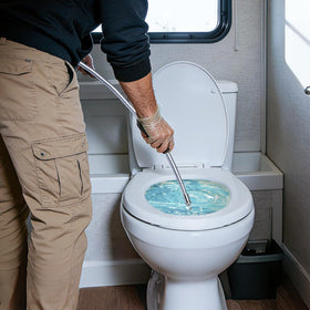 DigNew wand spraying inside an RV tank to loosen deposits and clean sensors
