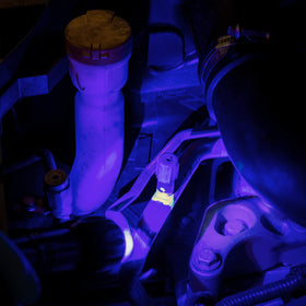 UV inspection revealing ERRECOM Brilliant fluorescence on a leaking A/C hose for fast detection