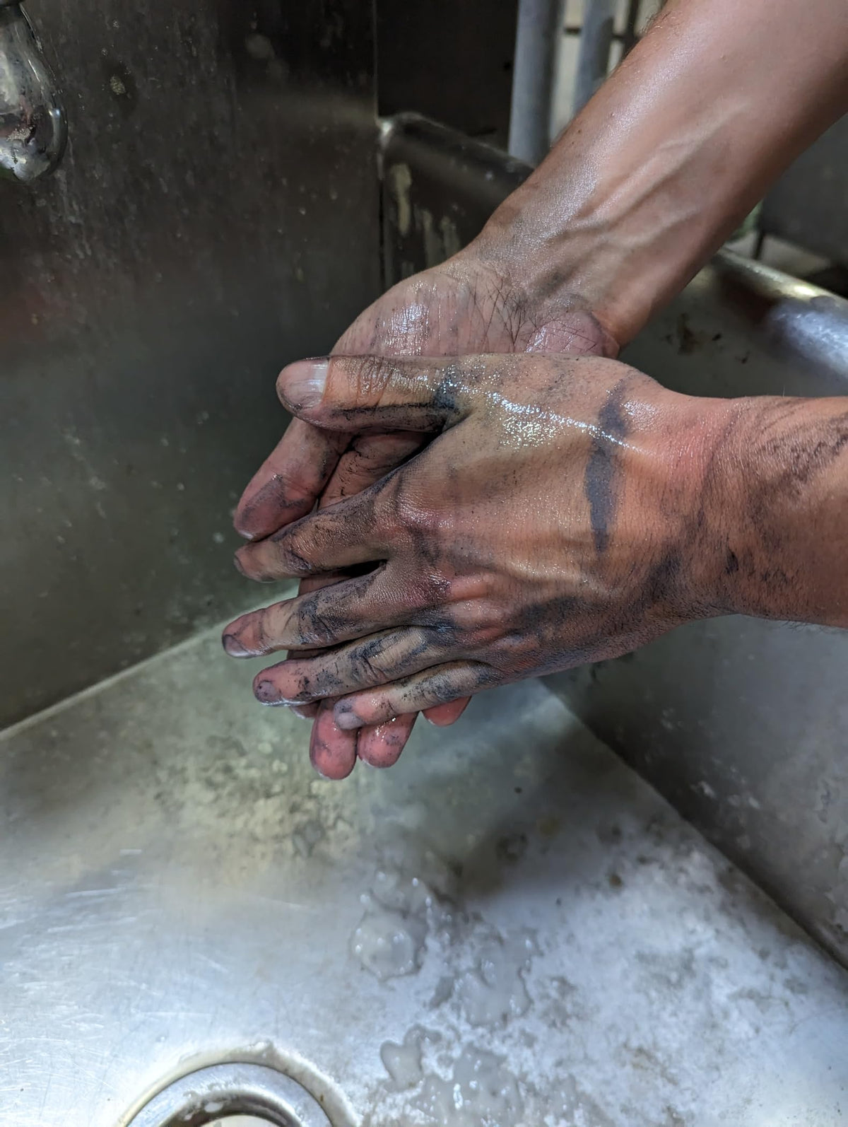 Mechanic using Fast Orange Xtreme at a shop sink removing grease for faster hand cleanup