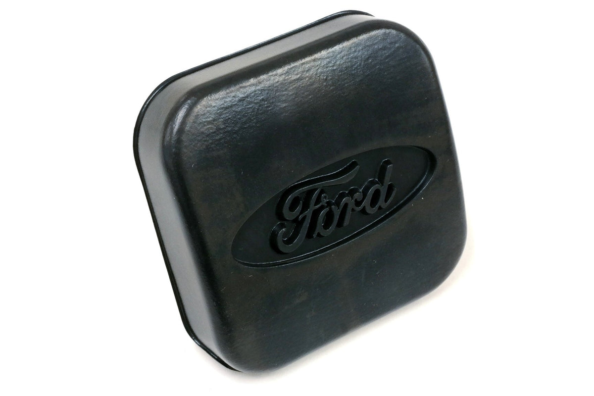 Ford trailer hitch cover beside ruler for accurate size comparison