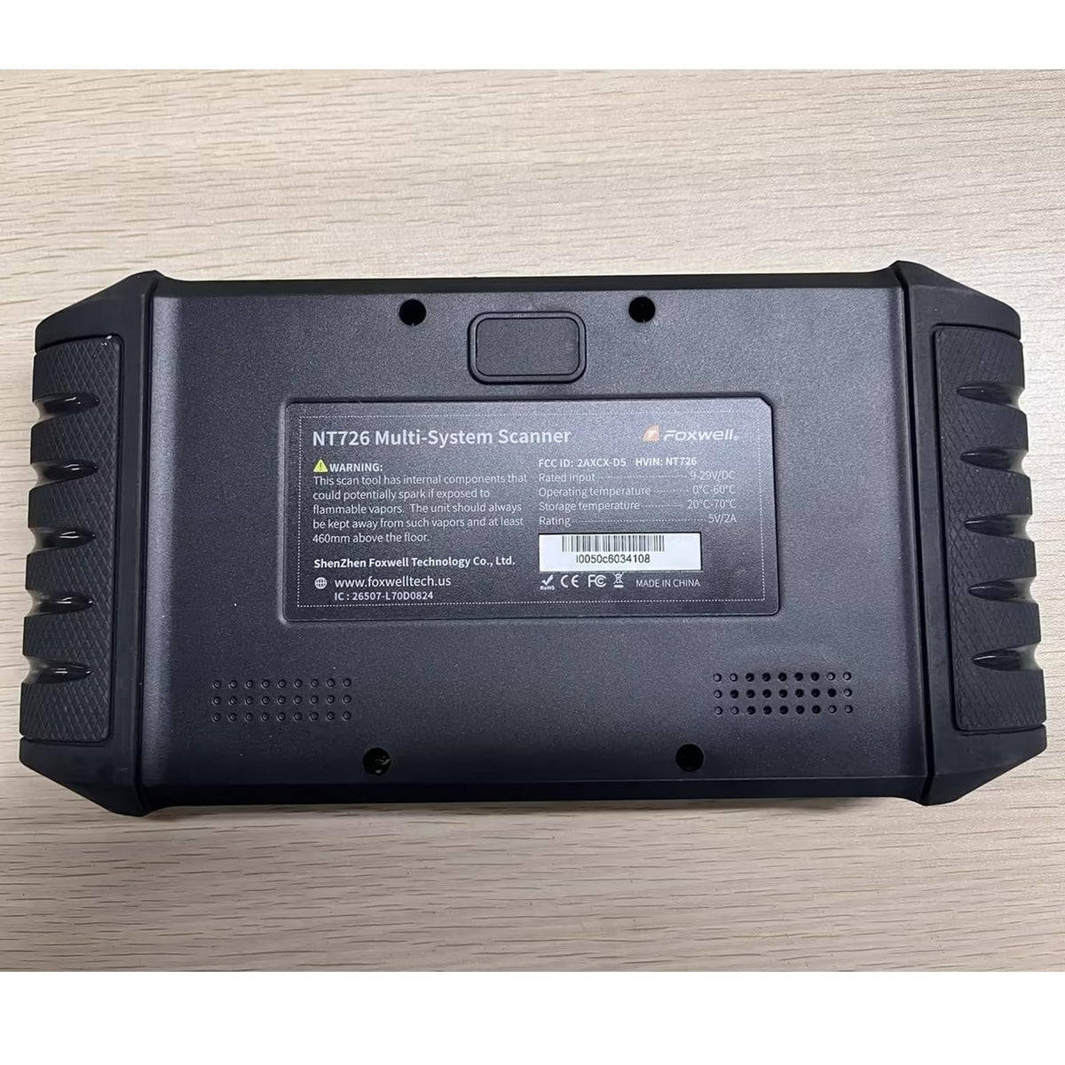 FOXWELL NT726 size comparison in hand to show portable, workshop-ready form