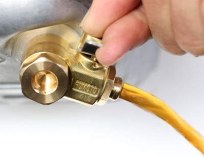 Fumoto F106SX next to a wrench showing size and easy-install scale advantage