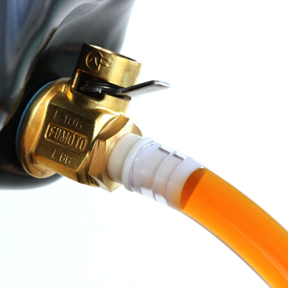 Fumoto F108S draining oil into container demonstrating controlled fluid release