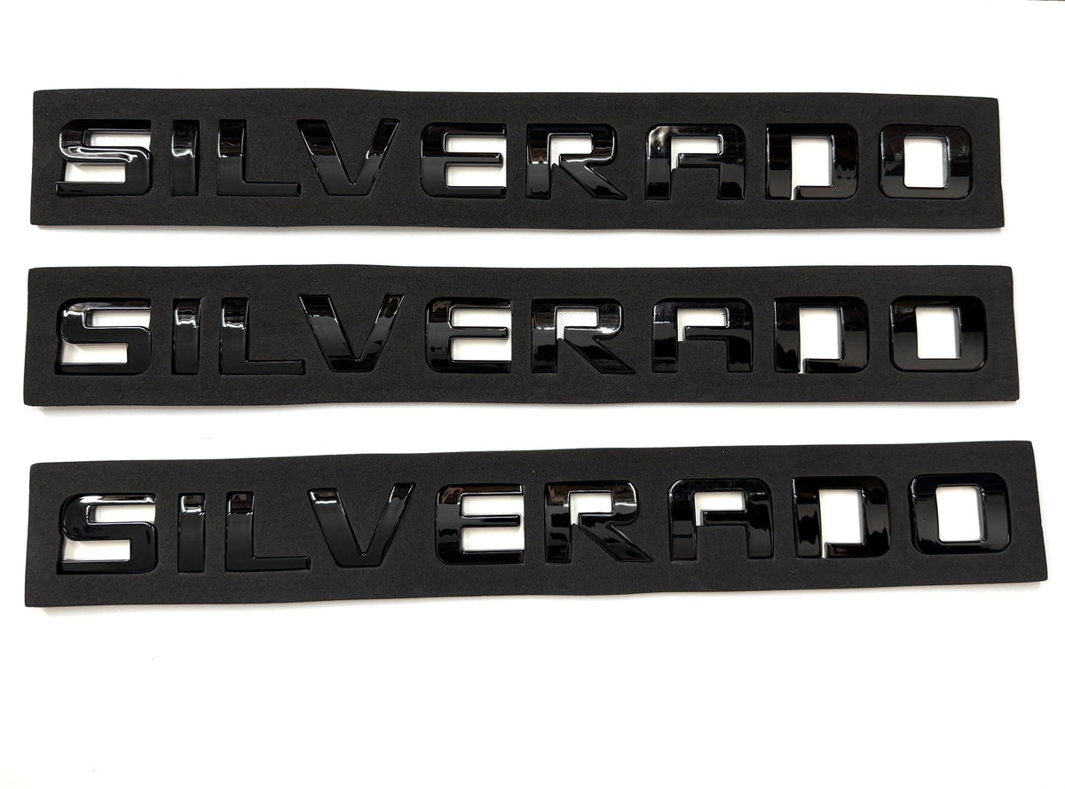Generic emblems installed on a Silverado tailgate showing restored appearance benefit