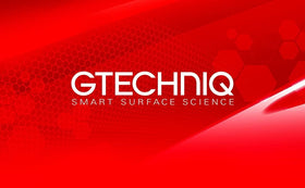 Detailer applying Gtechniq EXO on a parked car in driveway, lifestyle use demonstrating maintenance benefit