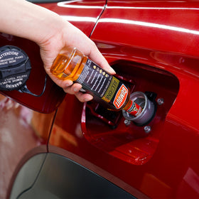 Gumout pouring into fuel filler demonstrating easy application and maintenance