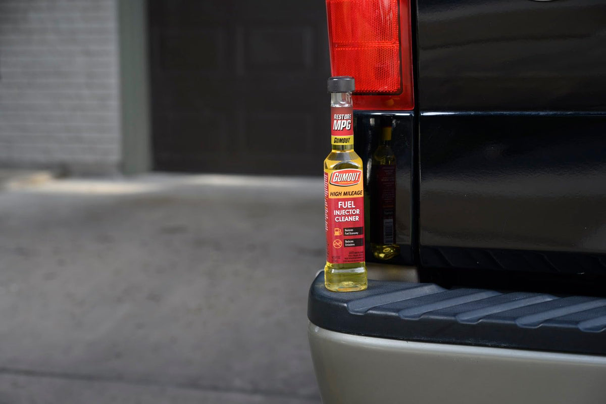 Gumout bottle in a garage setting showing practical maintenance for high-mileage vehicles