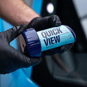 Gyeon QuickView bottle beside a hand to show compact portable size