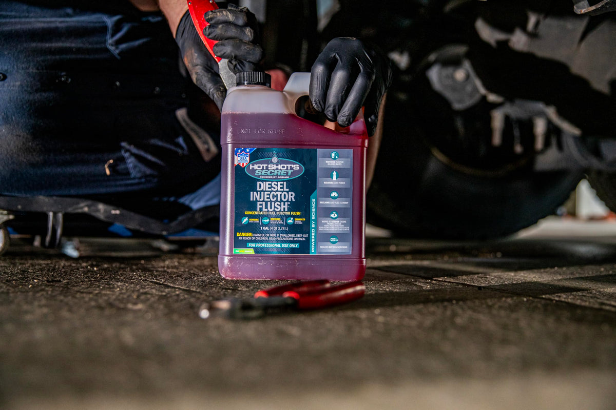 Hot Shot's Secret product staged in garage with diesel truck showing professional use