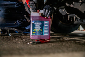 Hot Shot's Secret product staged in garage with diesel truck showing professional use