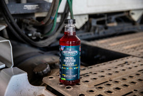 Hot Shot's Secret bottle on a workshop bench showing fleet maintenance benefit