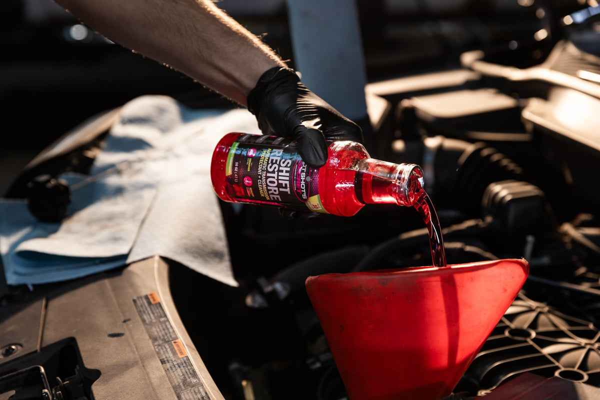 Hot Shot's Secret 16 oz bottle held beside a hand for size and scale