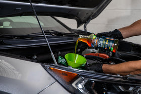 Hot Shot's Secret bottle next to open engine bay showing in-use benefit