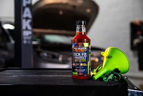 Hot Shot's Secret bottle beside a measuring cup showing 32 oz scale